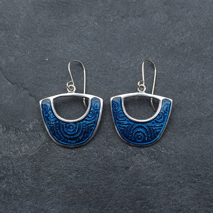 Midnight blue enamel on silver earrings, shield cutout shape, on a  slate grey background